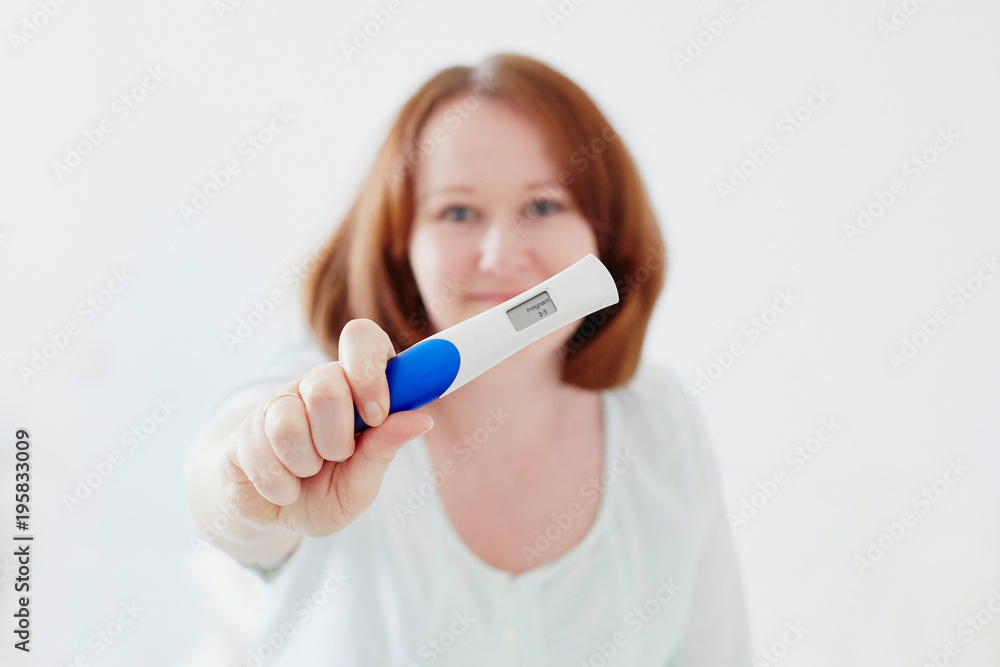 Happy young woman showing positive pregnancy test Happy young woman showing positive pregnancy test