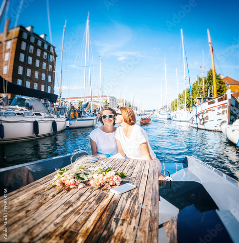 Photography A beautiful female lesbian couple in white dresses on a boat, a wedding in Denma