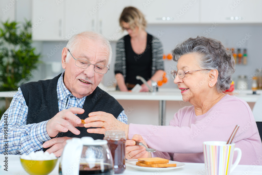 happy senior couple discussing while having breakfast at table happy senior couple discussing while having breakfast at table