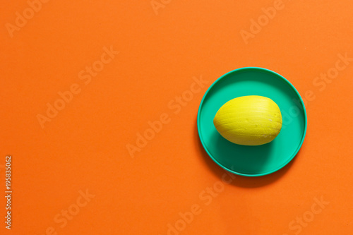 Yellow Easter egg on a bright orange background. Copy space. © AnastazjaSoroka