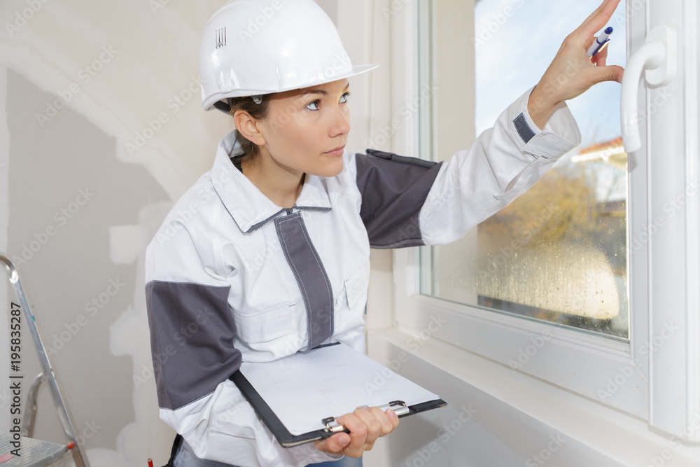 woman measuring the wall with tape measure woman measuring the wall with tape measure