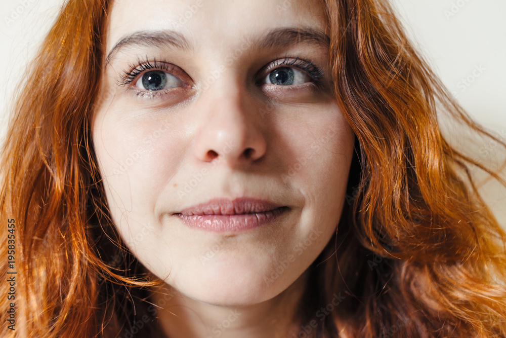 Portrait of beautiful cheerful redhead girl with curly hair over beige background. Hair dyed with henna. Professional hair care. Portrait of beautiful cheerful redhead girl with curly hair over beige background. Hair dyed with henna. Professional hair care.