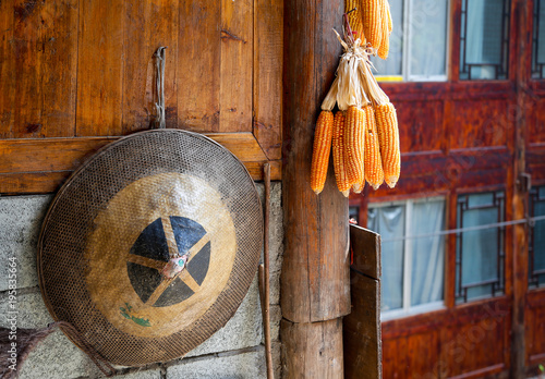 Chinese traditional farmer hat and bunches of dry corn hanging on wooden house, longji, Longsheng, China photo