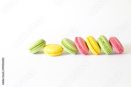 Three different types of macaroons colors pink, green and yellow isolated on white background. photo