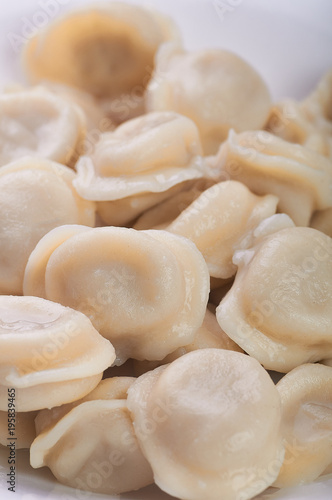 Appetizing dumplings, vareniki, ravioli, momo close-up. Traditional dish of Russia, Italy, Asia. Boiled dough with filling. Dumplings with meat, fish, vegetables. A hearty breakfast, lunch, dinner.