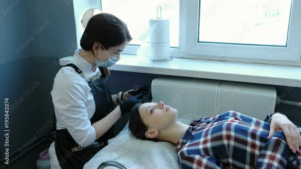 Beauty treatment. Beautician puts on rubber gloves and prepares for the procedure. Client lies on the couch. Beauty treatment. Beautician puts on rubber gloves and prepares for the procedure. Client lies on the couch.