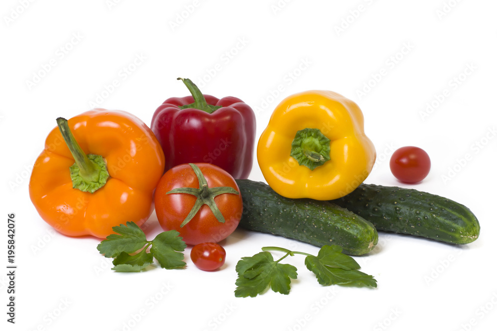 Red yellow and orange peppers with tomatoes on a white background..Cucumbers with colorful peppers in composition on a white background. Red yellow and orange peppers with tomatoes on a white background..Cucumbers with colorful peppers in composition on a white background.
