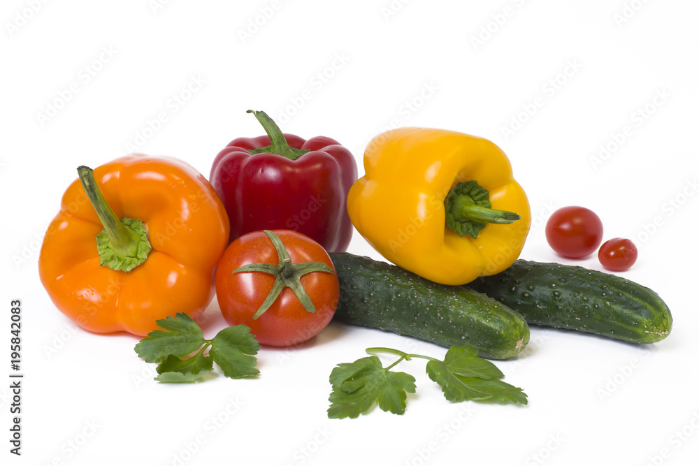 Red yellow and orange peppers with tomatoes on a white background..Cucumbers with colorful peppers in composition on a white background. Red yellow and orange peppers with tomatoes on a white background..Cucumbers with colorful peppers in composition on a white background.
