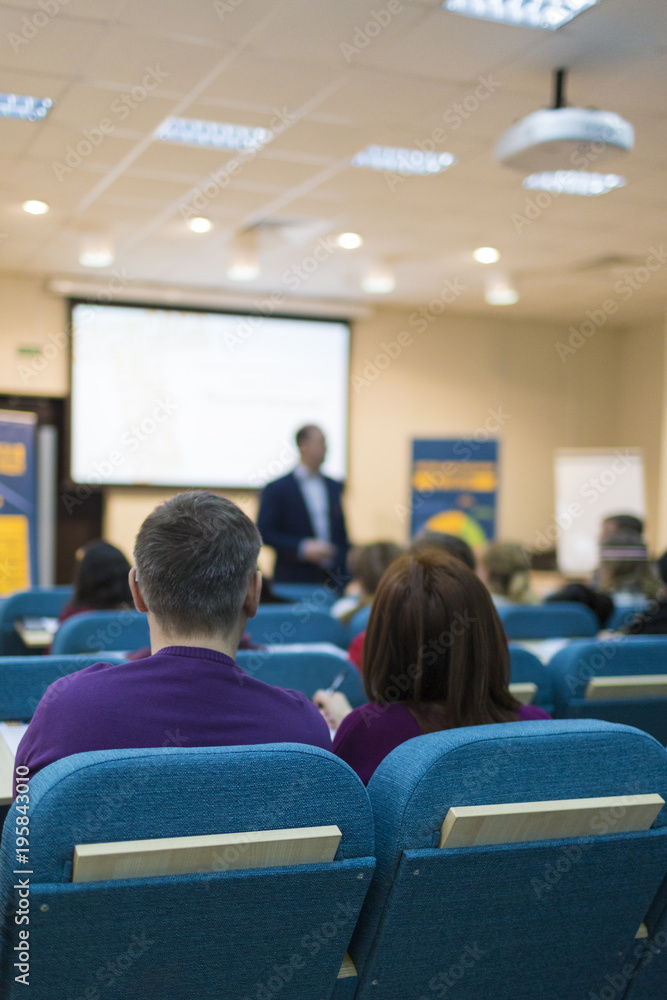 Conferences and Business Meetings Concepts. Mature Experienced Male Presenter Giving a Talk in Front of the Group Of Listeneres During a Conference. Conferences and Business Meetings Concepts. Mature Experienced Male Presenter Giving a Talk in Front of the Group Of Listeneres During a Conference.