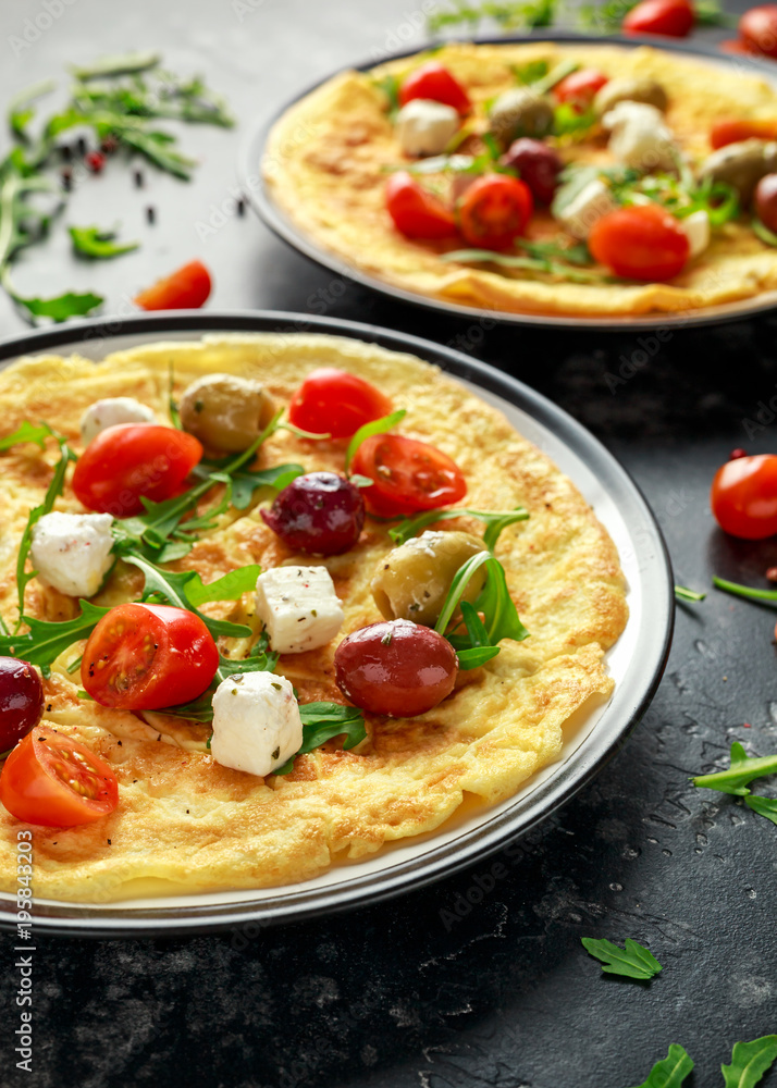 Vegetables Eggs Omelette with tomatoes, wild rocket, greek cheese, olives in a plate. Morning breakfast. healthy food Vegetables Eggs Omelette with tomatoes, wild rocket, greek cheese, olives in a plate. Morning breakfast. healthy food