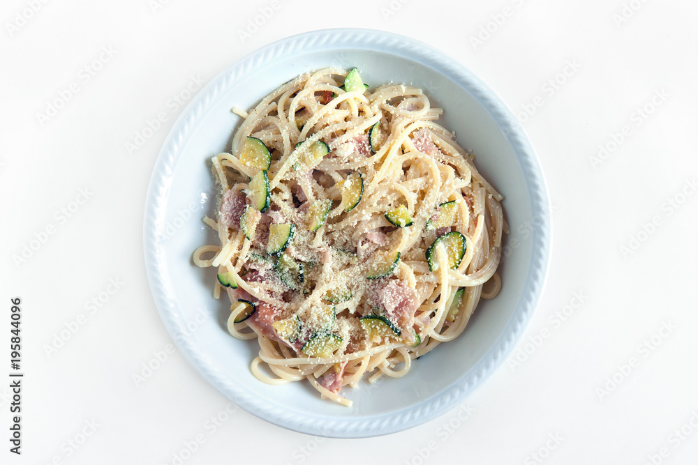 spaghetti with ham and zucchini with cheese, top view of the plate on white background spaghetti with ham and zucchini with cheese, top view of the plate on white background