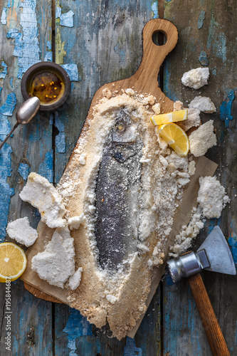 Fish baked in salt with lemon and oil, top view photo