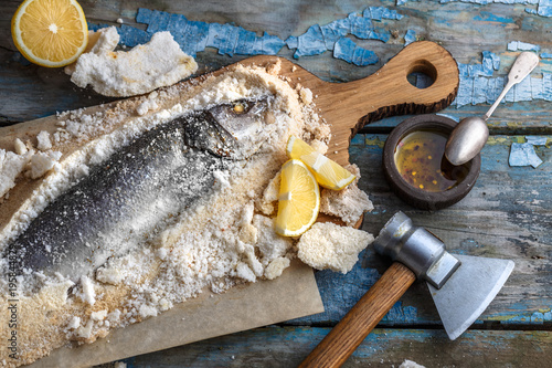 Fish baked in salt with lemon and oil, top view