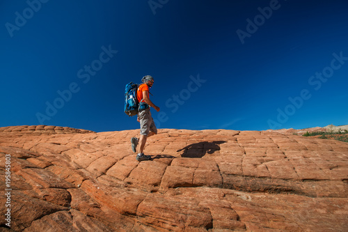 Hiker on a trail in volcanic Snow canyon State Park in Utah, USA