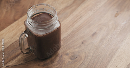 cocoa drink in glass jar with handle on wood table