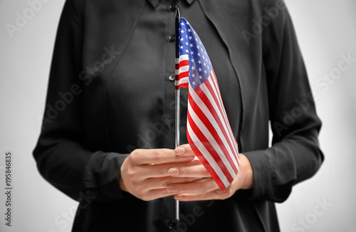Wallpaper Mural Woman holding American flag on light background. Immigration to USA Torontodigital.ca
