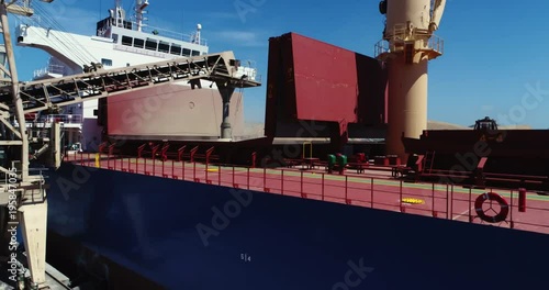 Drone flyover of unidentified bulk grain ship loading grain at southern Australian port. 