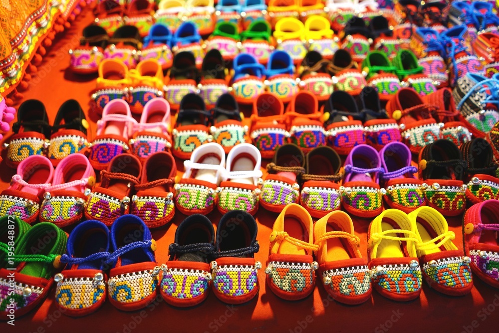 Rows of colorful hand made baby shoes in market