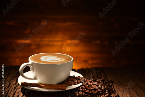 Cup of coffee latte and coffee beans on old wooden background