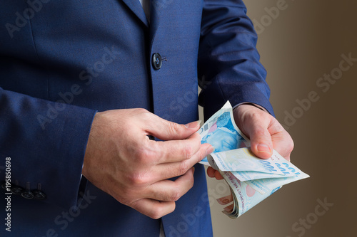 Wallpaper Mural Money investment. The man is counting Turkish lira. count money.  Torontodigital.ca