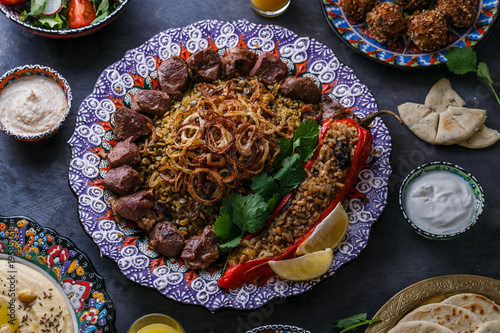 Mejadra or rice with lentils with shish kebab in traditional plate photo