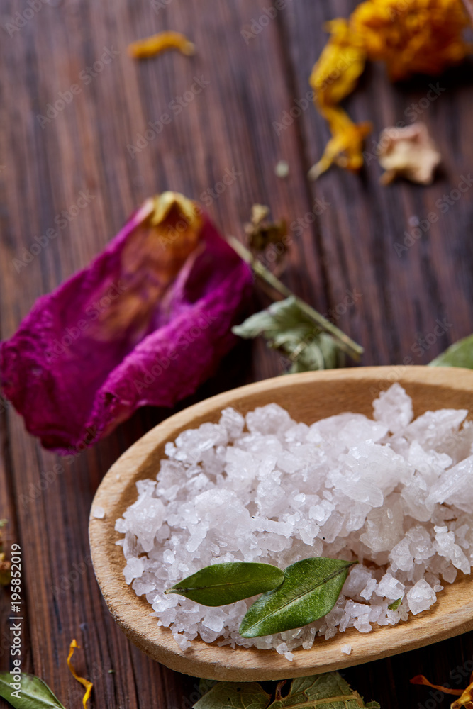 Composition of spa treatment on wooden background. Sea salt and flowers background, close up, top view, selective focus. Composition of spa treatment on wooden background. Sea salt and flowers background, close up, top view, selective focus.