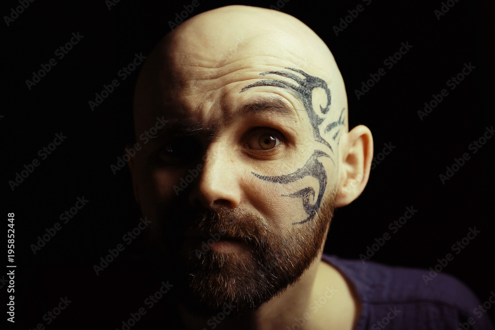 tattoo on the face, man with a tattoo, brutal bearded guy, studio portrait  of a man Stock Photo