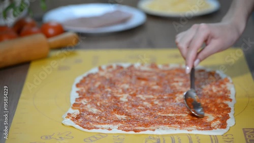 pizza dough with tomato sauce on table photo