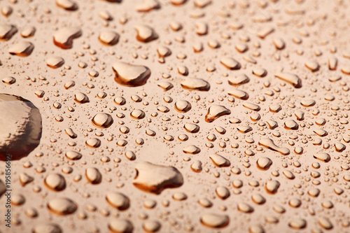 Colored water droplets on a gold background. Abstract liquid sprays
