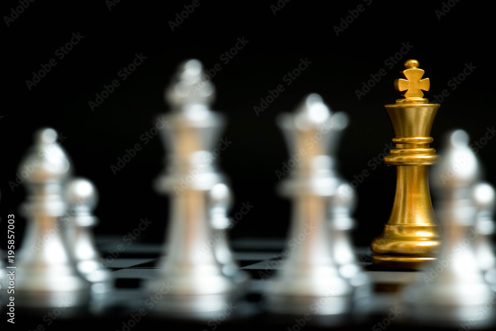 Gold king in chess game face with the another silver team on black background (Concept for company strategy, business victory or decision) Gold king in chess game face with the another silver team on black background (Concept for company strategy, business victory or decision)