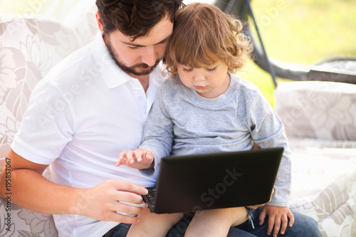 Father teaching his daughter using laptop computer.