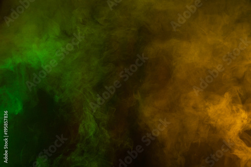 Green and yellow smoke texture on a black background. Texture and abstract art