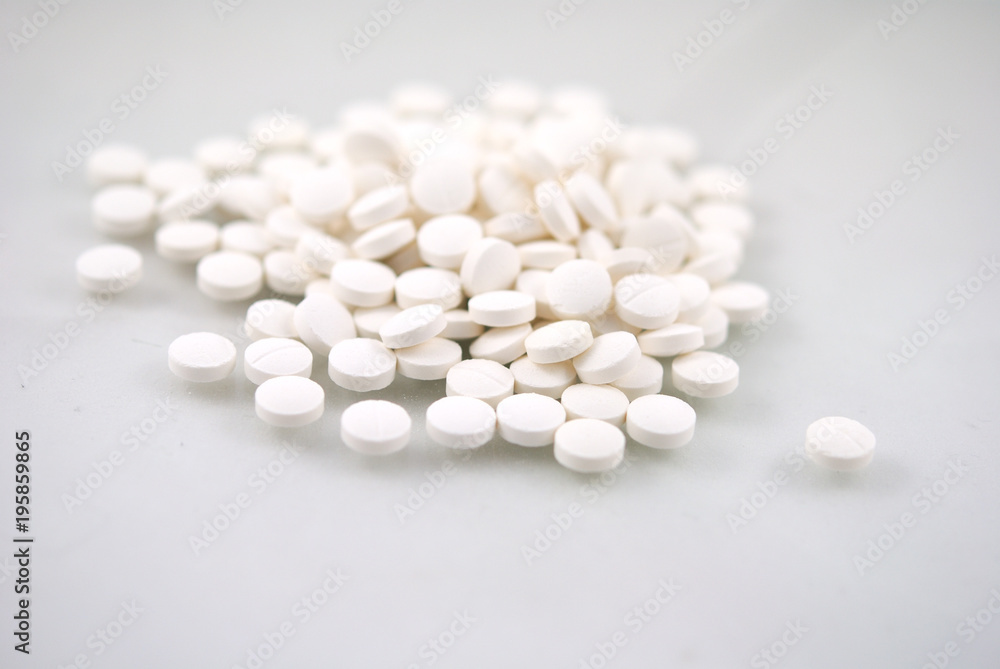 White round tablets close-up with reflection on white background White round tablets close-up with reflection on white background