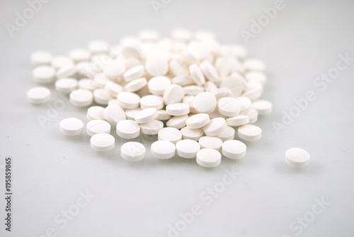 White round tablets close-up with reflection on white background