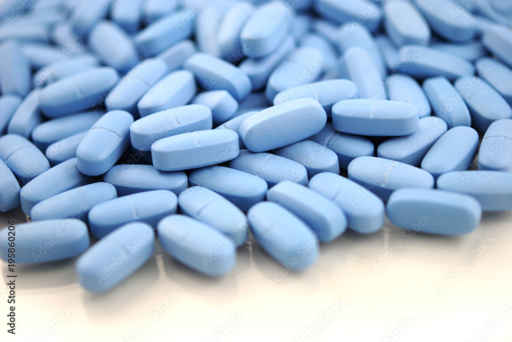 Light blue oval tablets with natural shadow closeup on white background Light blue oval tablets with natural shadow closeup on white background