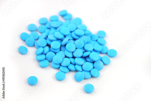 Bright blue tablets close-up on white background