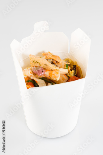 Chinese noodles in white box on isolated background with a chicken and vegetables
