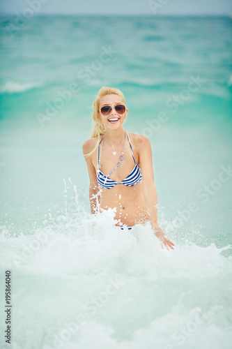 beautiful young and cheerful blond woman in a swimsuit bathing in the sea.