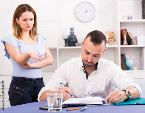 Husband is studying documents on divorce at the table