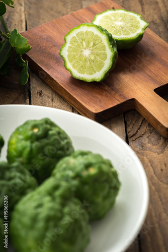 Kaffir lime or lime with white plate on wood


