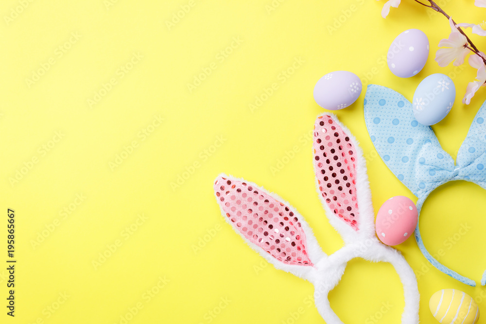 Top view shot of arrangement decoration Happy Easter holiday background concept.Flat lay colorful bunny eggs with accessory ornament on modern beautiful yellow paper at office desk.Design pastel tone.