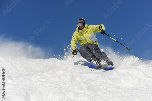Bearded skier running down the mountain slope in resort of Gudauri, Georgia