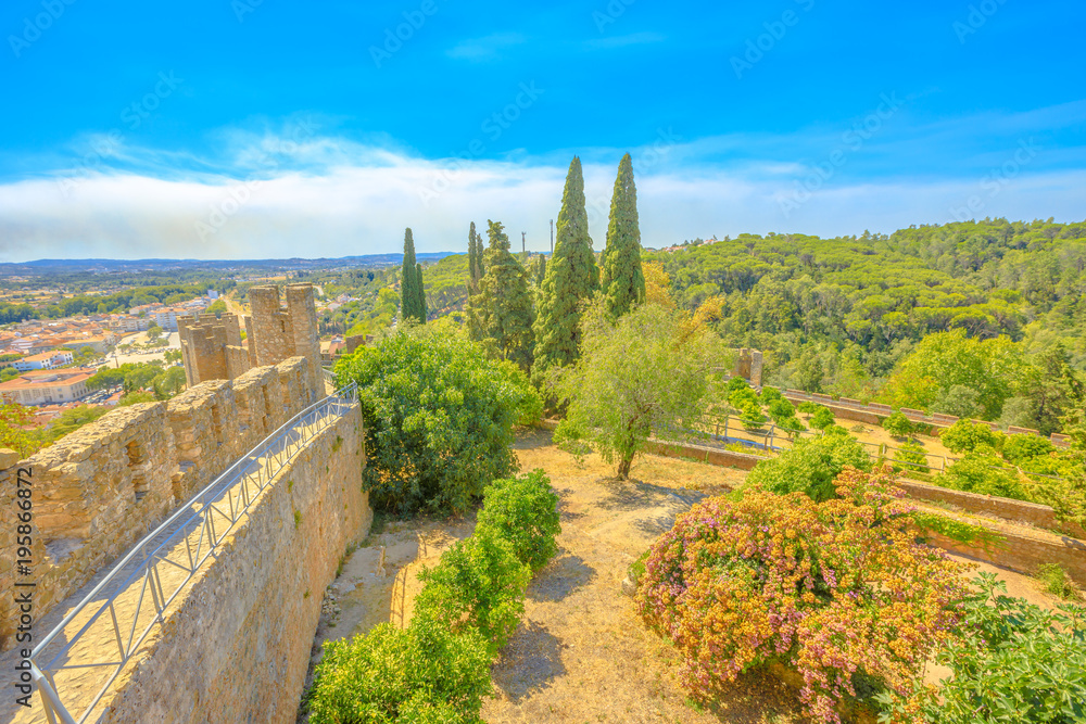 Aerial view of Tomar Castle garden from ancient ruins of walls in Tomar, Portugal, Europe. Tomar city skyline in summer season. Blue sky. Famous landmark Unesco heritage.