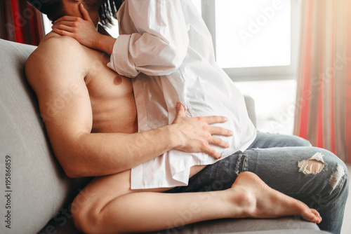 Sexy woman sitting on man, intimate games on couch photo