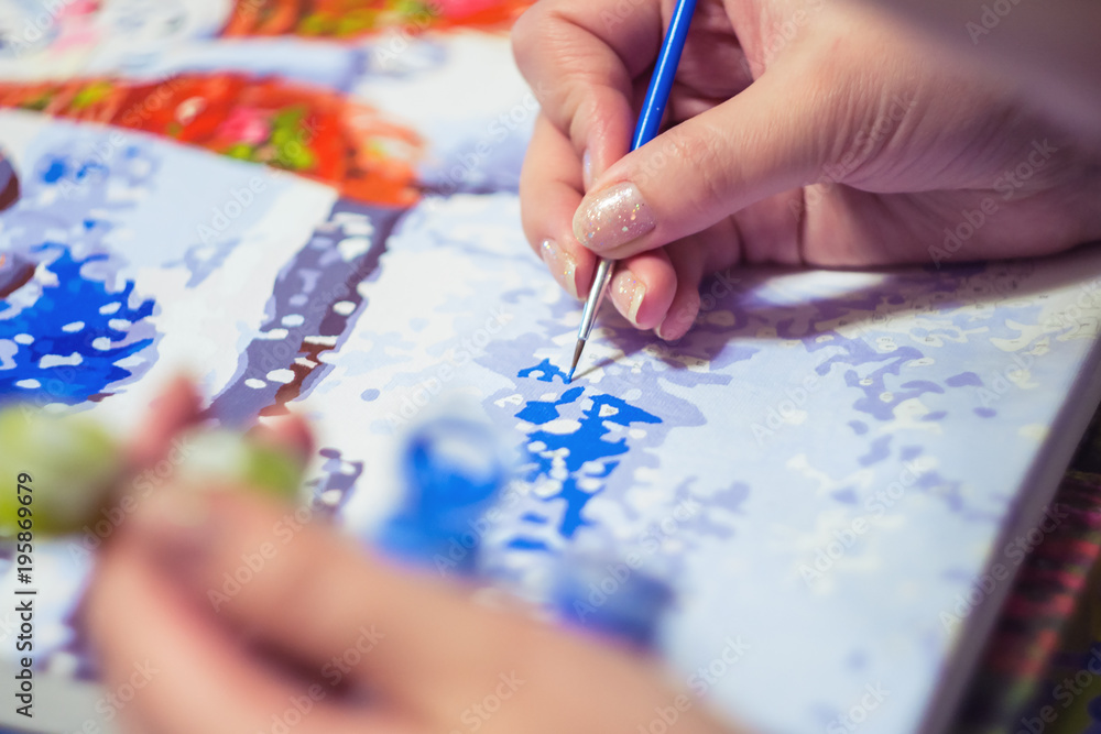 Woman is drawing the paint by numbers Woman is drawing the paint by numbers