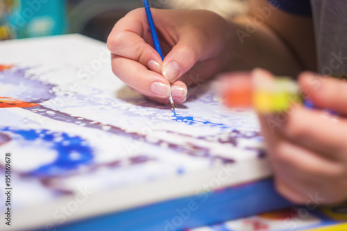 Woman is drawing the paint by numbers