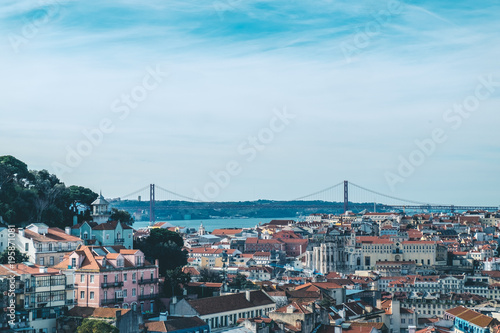 Lisbon. Bridge and Jesus Christ in background. Rooftops. Sunny spring day.