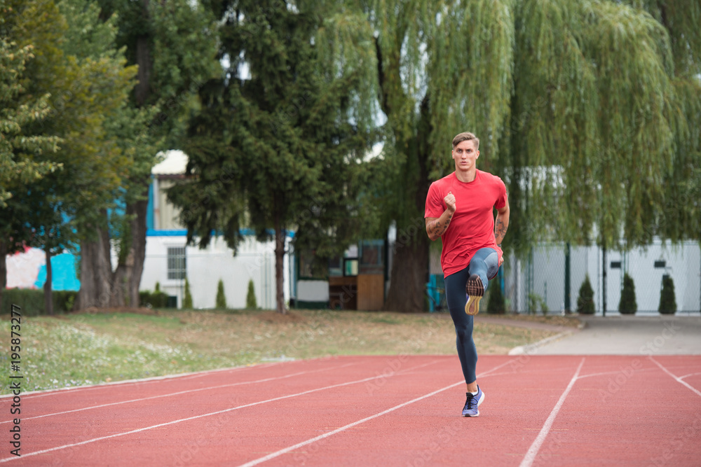 Young Male Athlete Running on Track