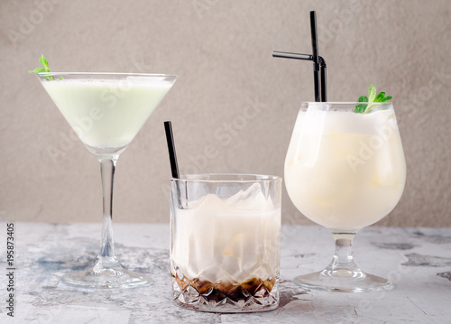 group of cocktails on a restaurant background: pina colada, coffee cocktail Black Russian, liquor in glasses and cream milk cocktail with mint. Bar alcohol menu.