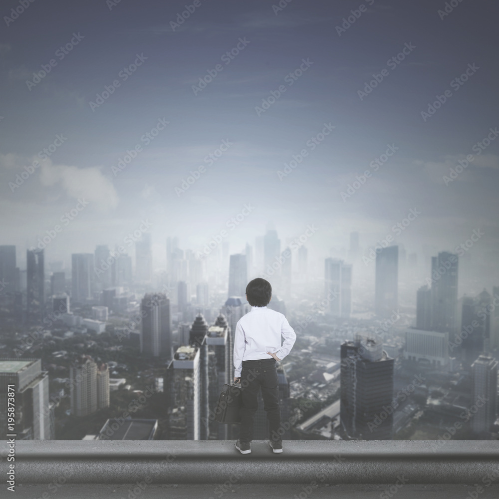 Little boy with suitcase on rooftop